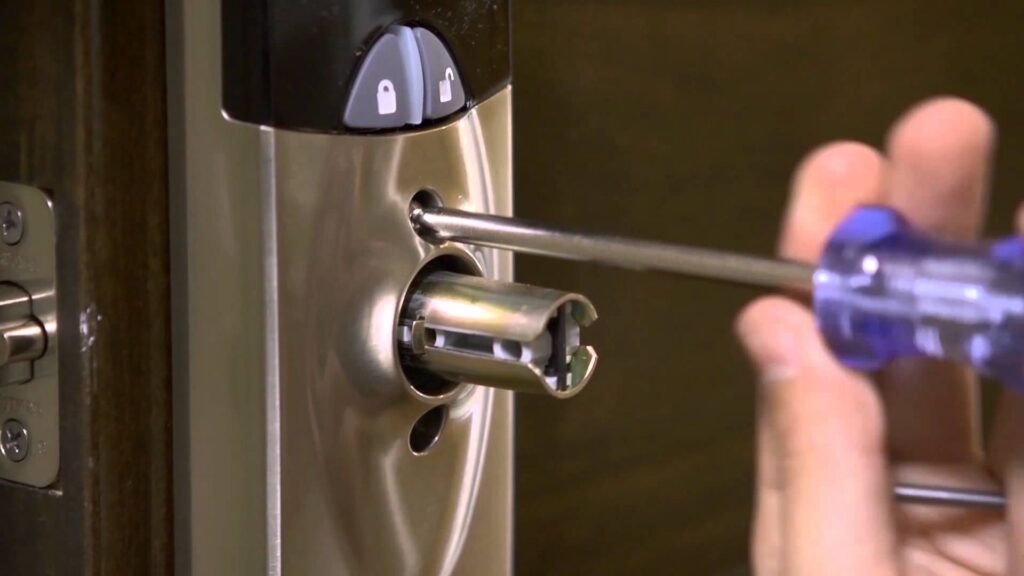 hand holding screwdriver removing a screw to open a commercial lock