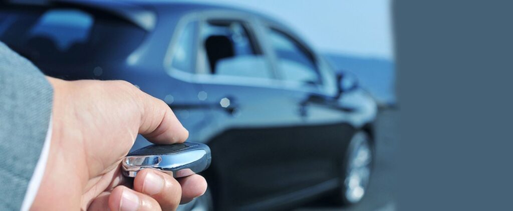 hand click a fob key next to an auto car to open the vehicle
