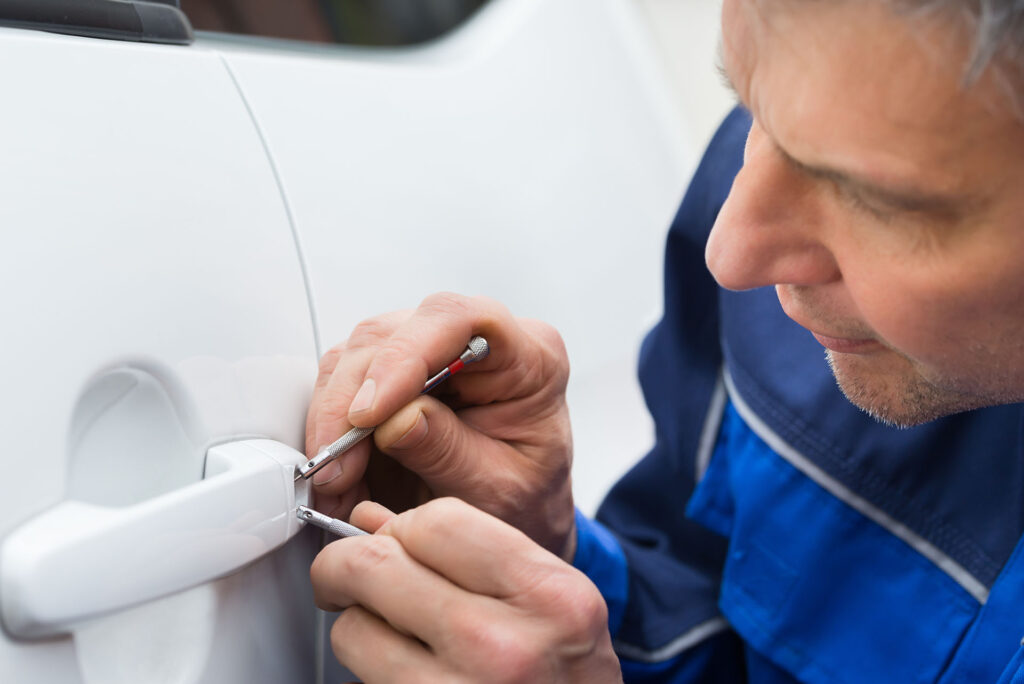 Close-up Of emergency locksmith tech Hand Holding Lock picking tool To Open Car Door