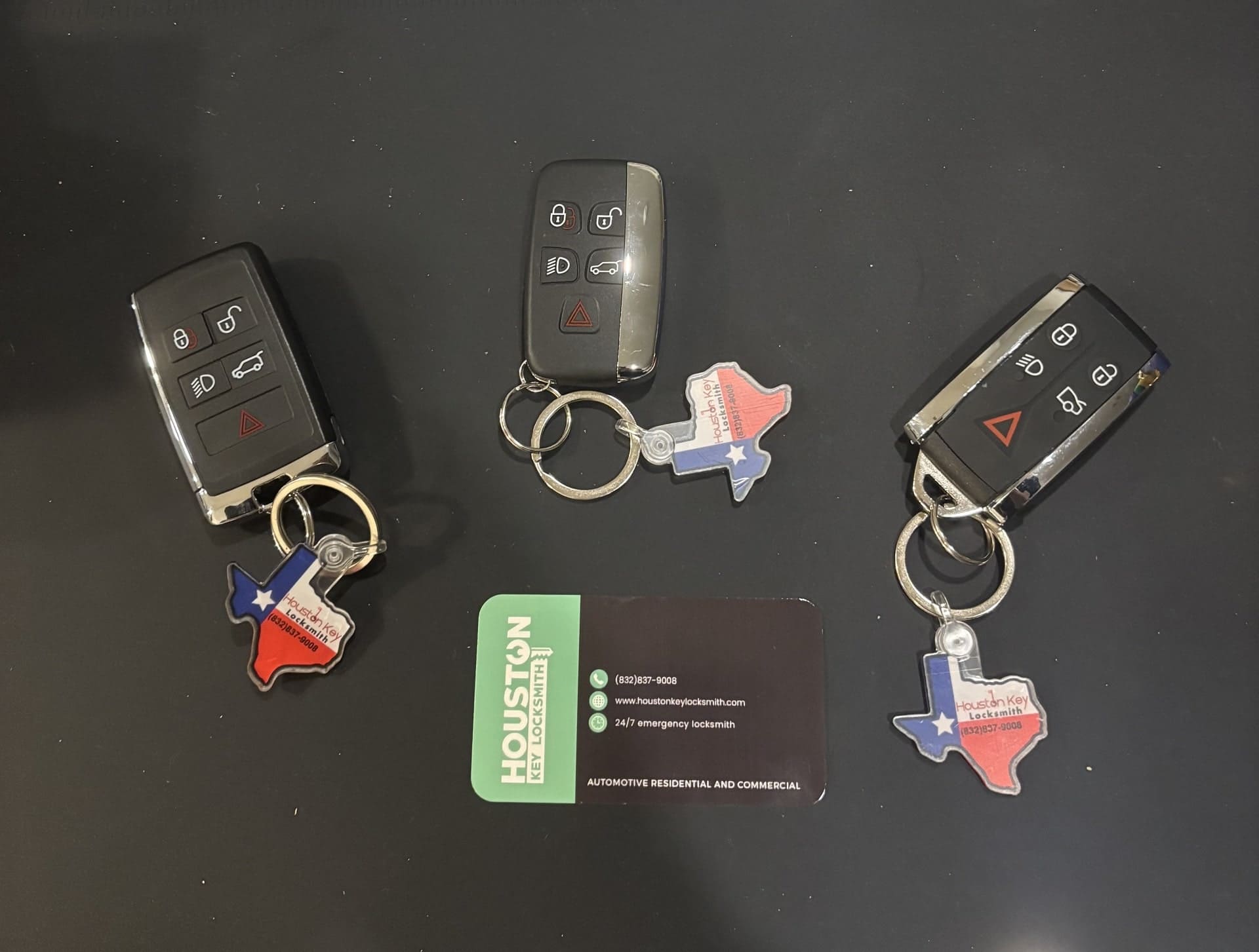 Professional Jaguar and Range Rover car key replacement service in Houston, featuring a Land Rover smart key fob and battery
