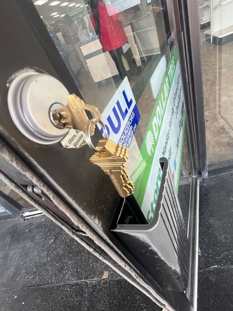 Professional locksmith technician performing a commercial lock change service in downtown Houston.