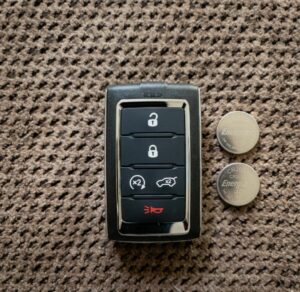 Jeep Smart Key ob next to CR2032 Replacement coin batteries, highlighting a car key not working after battery replacement.