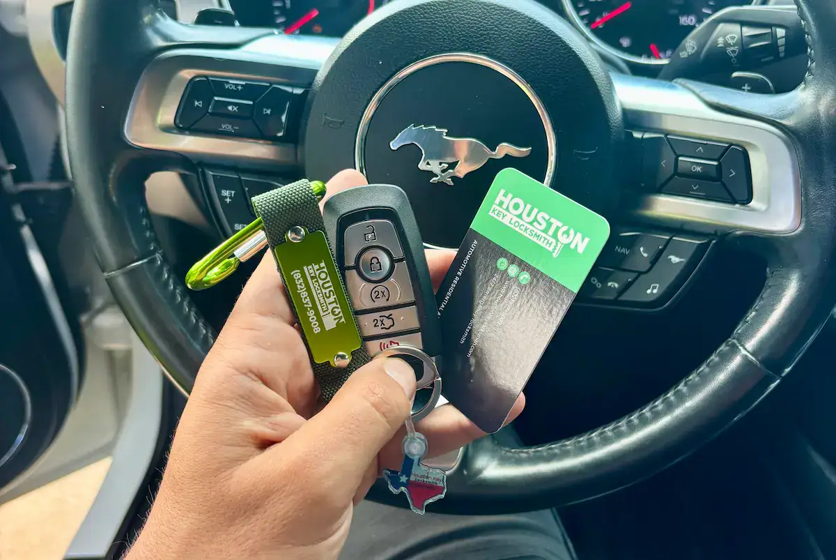 Hand holding a newly programmed Ford car key replacement for a Houston locksmith service.