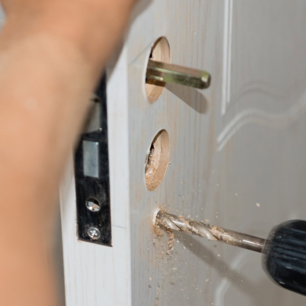 Locksmith changing a residential door lock
